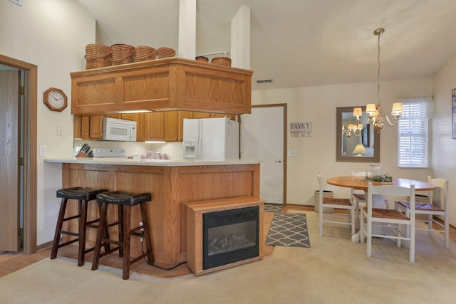 kitchen with pendant lighting, white appliances, light carpet, a notable chandelier, and kitchen peninsula