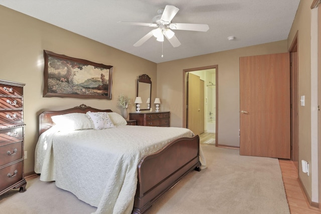 bedroom featuring ceiling fan, light hardwood / wood-style floors, and connected bathroom