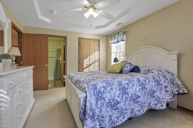 carpeted bedroom with a raised ceiling, ceiling fan, and crown molding