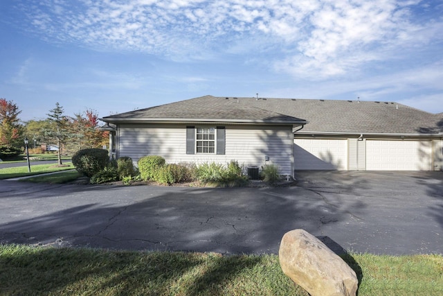 view of side of home featuring a garage and central air condition unit