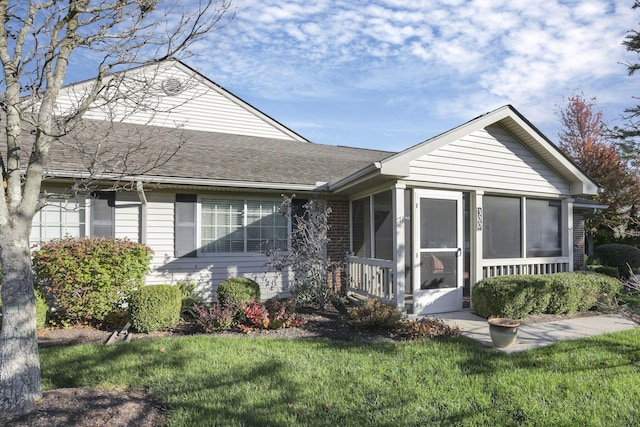 ranch-style house with a sunroom and a front yard