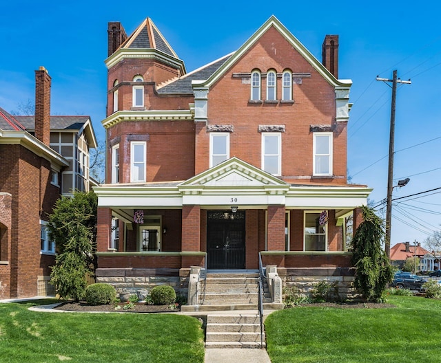 view of front of property featuring covered porch and a front lawn