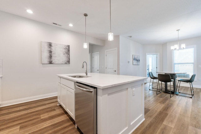 kitchen with sink, light hardwood / wood-style flooring, a chandelier, a kitchen island with sink, and white cabinets