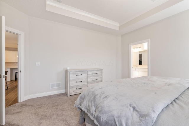 bedroom featuring light carpet and ensuite bath