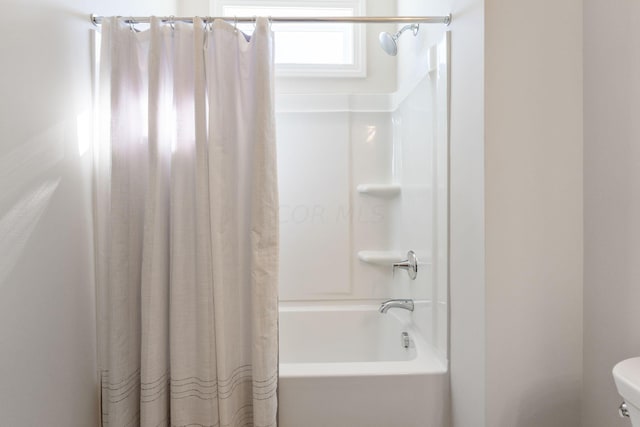 bathroom featuring shower / bath combo and toilet