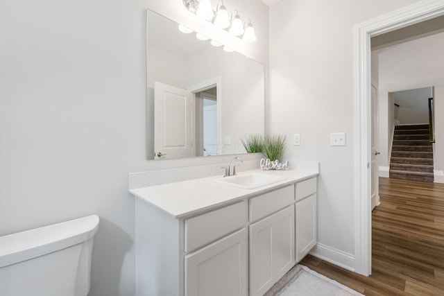 bathroom featuring vanity, hardwood / wood-style flooring, and toilet