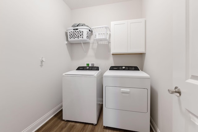 laundry room featuring washer and clothes dryer, cabinets, and dark wood-type flooring