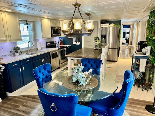 dining room featuring an inviting chandelier, light hardwood / wood-style flooring, and sink