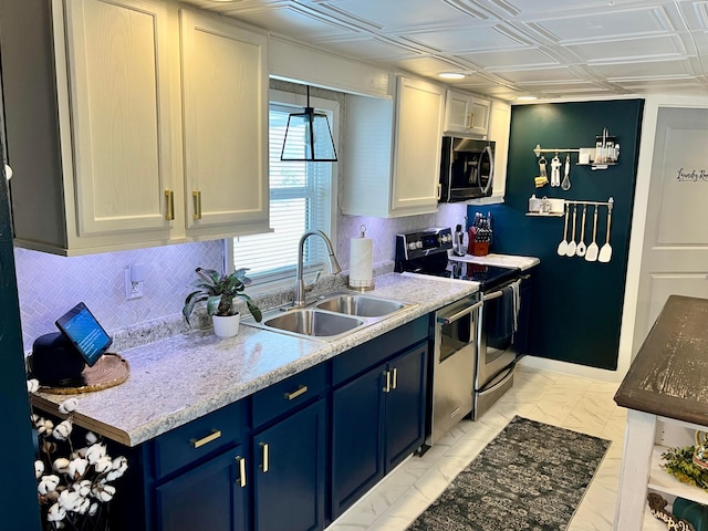 kitchen featuring sink, white cabinetry, blue cabinetry, stainless steel appliances, and light stone counters