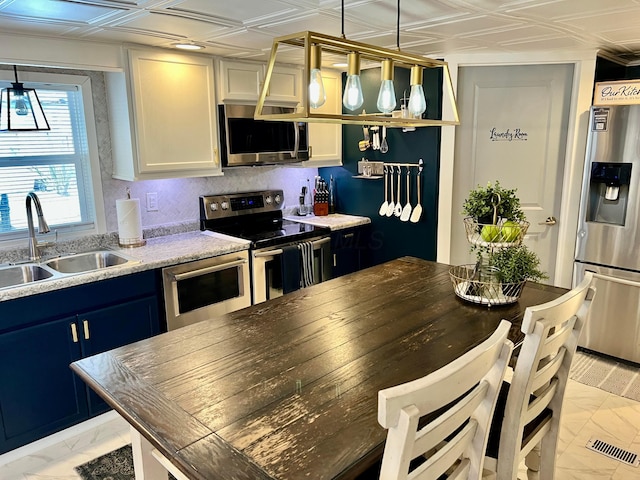 kitchen with white cabinetry, appliances with stainless steel finishes, decorative light fixtures, blue cabinets, and sink