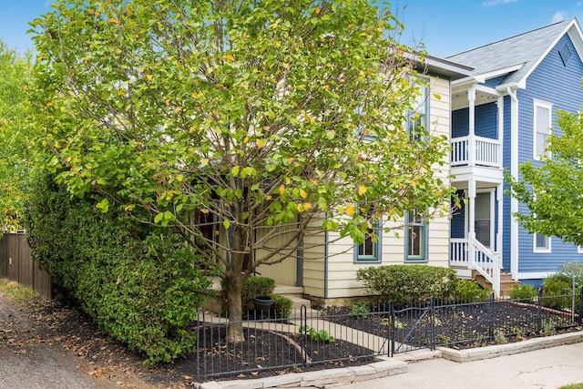 view of property hidden behind natural elements featuring a balcony