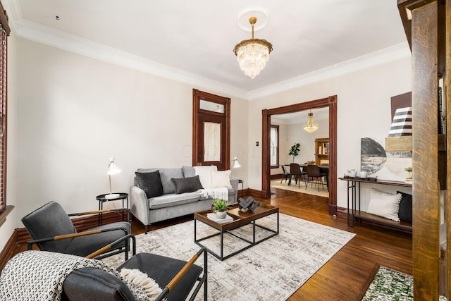 living room featuring crown molding, dark wood-type flooring, and a chandelier