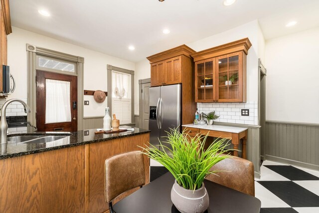 kitchen featuring dark stone counters, sink, appliances with stainless steel finishes, tasteful backsplash, and kitchen peninsula