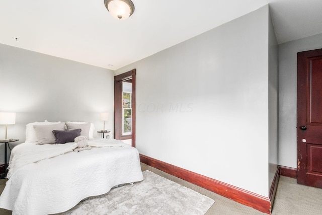 bedroom featuring light colored carpet and lofted ceiling