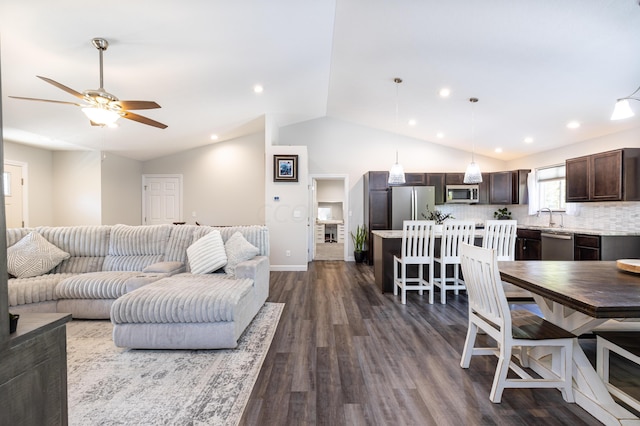 living room featuring dark hardwood / wood-style flooring, ceiling fan, lofted ceiling, and sink