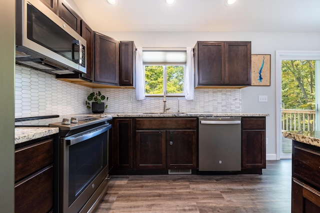 kitchen with dark hardwood / wood-style floors, a healthy amount of sunlight, and appliances with stainless steel finishes