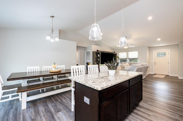 kitchen featuring a center island, hanging light fixtures, dark hardwood / wood-style floors, lofted ceiling, and ceiling fan with notable chandelier