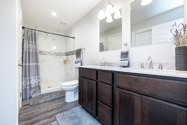 bathroom with vanity, hardwood / wood-style flooring, toilet, a notable chandelier, and curtained shower