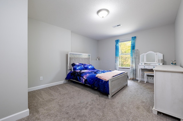 carpeted bedroom featuring a textured ceiling