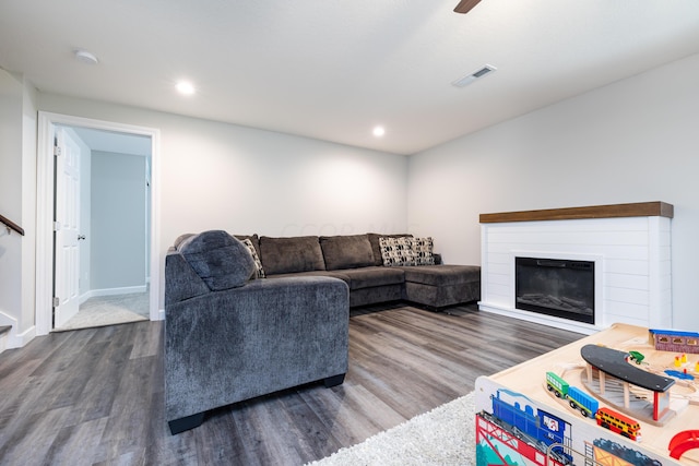 living room featuring ceiling fan and dark hardwood / wood-style flooring