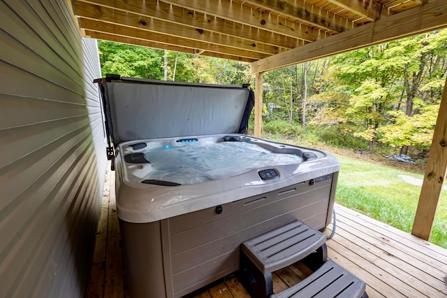 view of patio / terrace with a hot tub and a deck