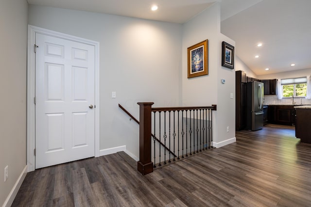 hall featuring dark hardwood / wood-style flooring, sink, and vaulted ceiling