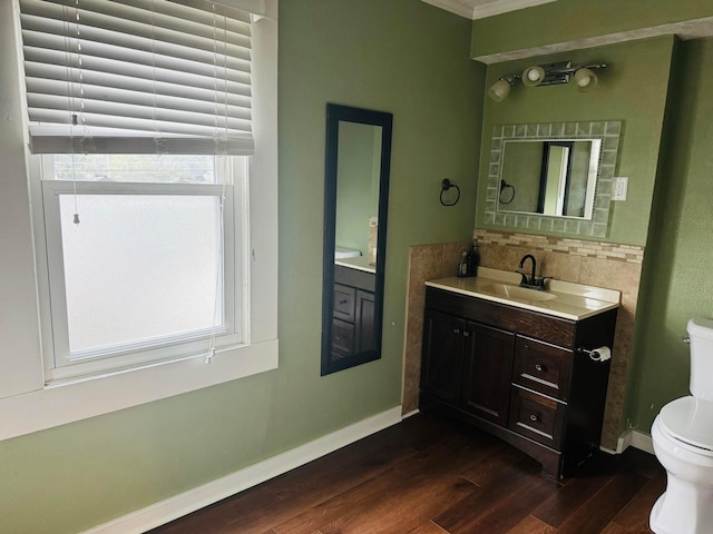 bathroom featuring vanity, hardwood / wood-style flooring, toilet, and ornamental molding