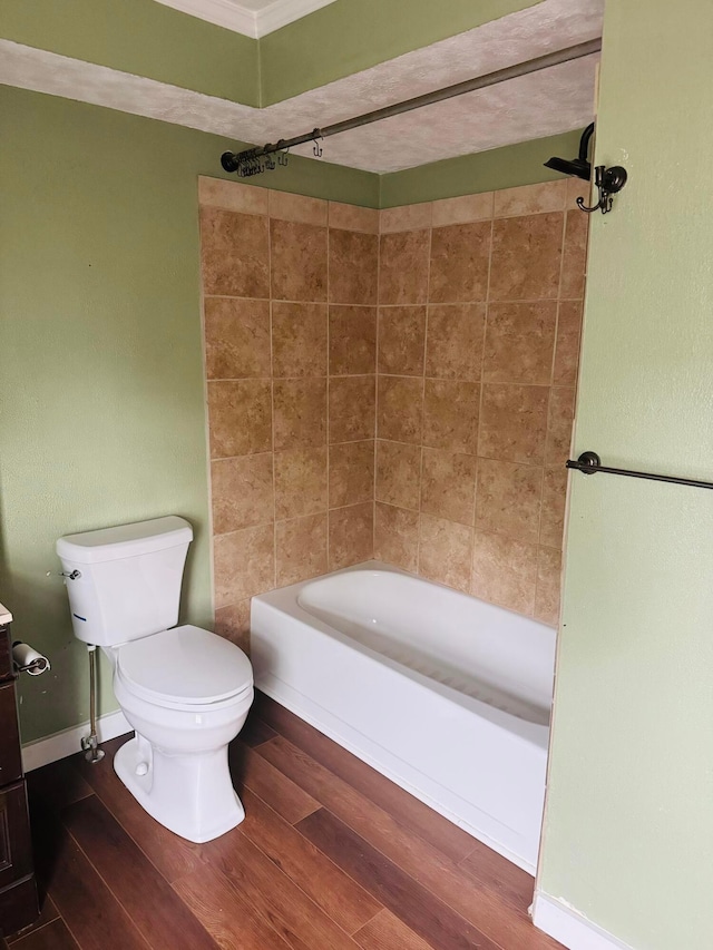 bathroom featuring hardwood / wood-style floors, toilet, and tiled shower / bath