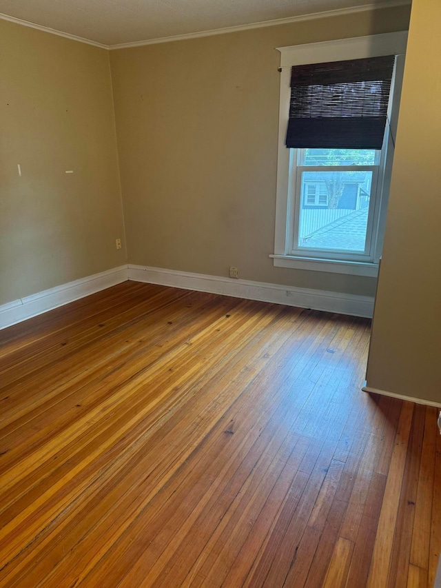 unfurnished room with hardwood / wood-style floors and ornamental molding