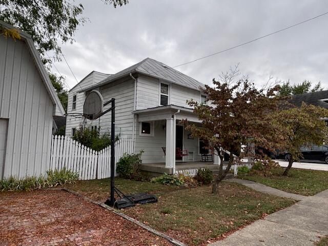 view of side of property featuring a porch and a yard