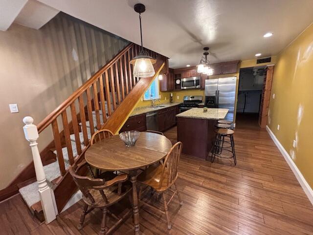 dining space with dark hardwood / wood-style floors and sink