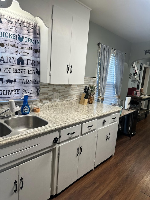 kitchen featuring decorative backsplash, dark hardwood / wood-style flooring, white cabinetry, and sink