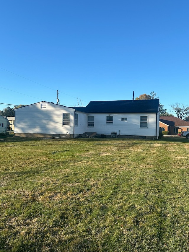 rear view of property featuring a lawn