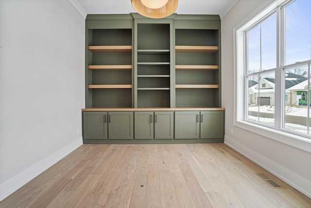 interior space with light hardwood / wood-style floors and built in shelves