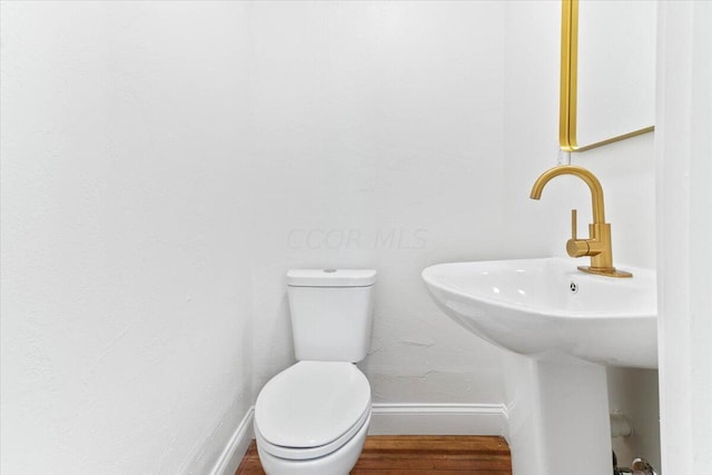 bathroom featuring hardwood / wood-style floors, toilet, and sink