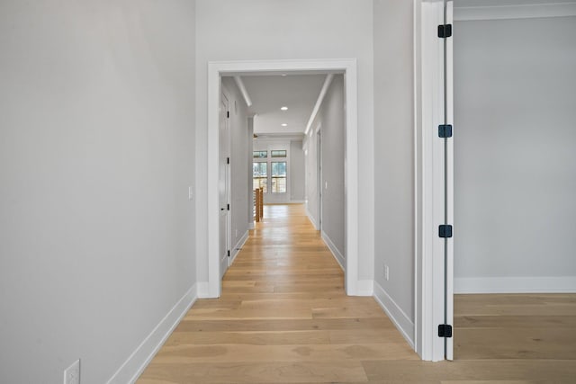 corridor featuring light hardwood / wood-style floors and crown molding