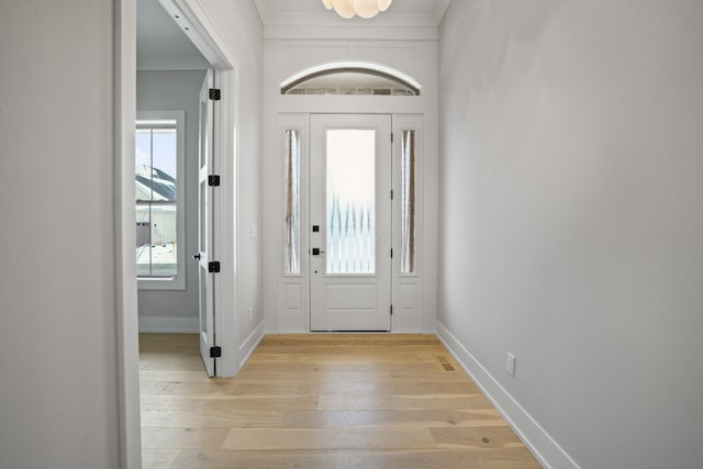 entrance foyer with crown molding and light hardwood / wood-style flooring