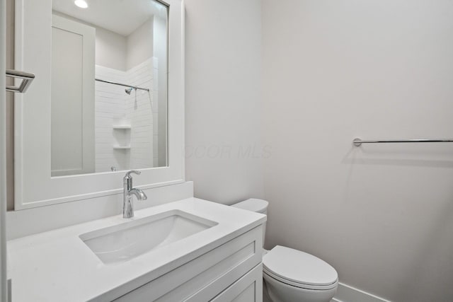 bathroom featuring vanity, toilet, and walk in shower