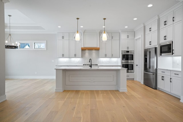 kitchen with white cabinetry, pendant lighting, an island with sink, and stainless steel appliances