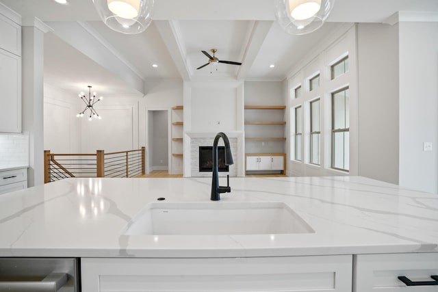 kitchen featuring white cabinets, light stone countertops, and sink