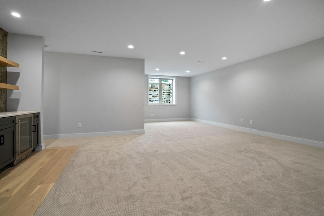 unfurnished living room with light carpet and wine cooler