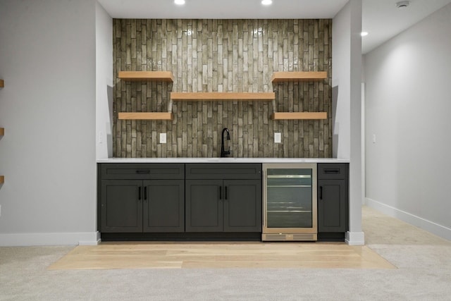 bar featuring wine cooler, decorative backsplash, and sink