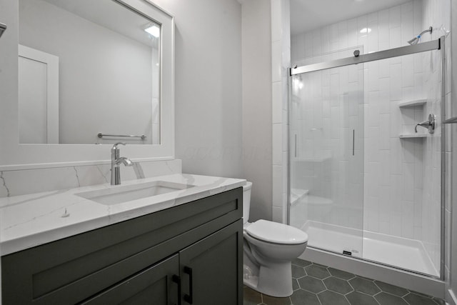 bathroom with walk in shower, tile patterned flooring, vanity, and toilet