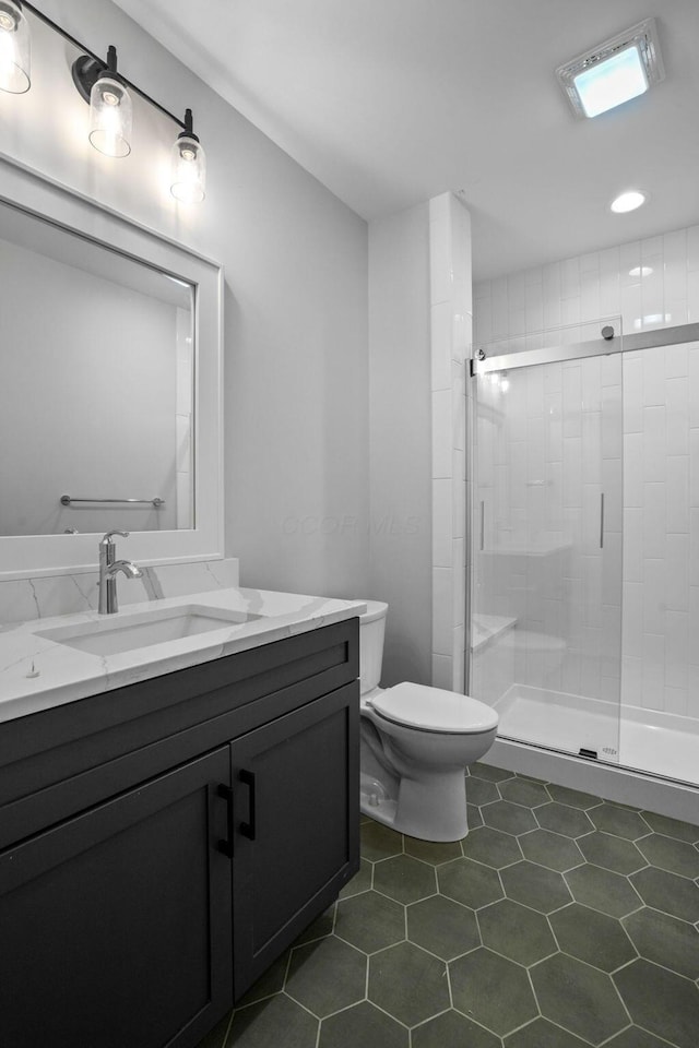 bathroom with tile patterned flooring, vanity, a shower with door, and toilet