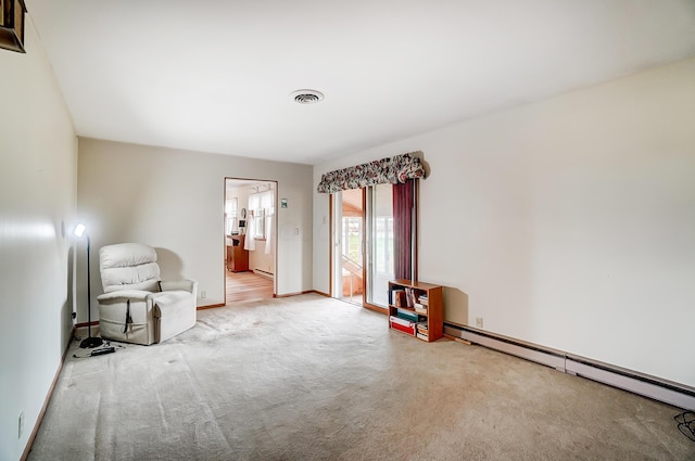 unfurnished room featuring a baseboard heating unit and light carpet