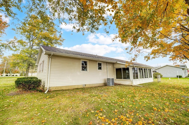 rear view of property with a sunroom, cooling unit, and a lawn