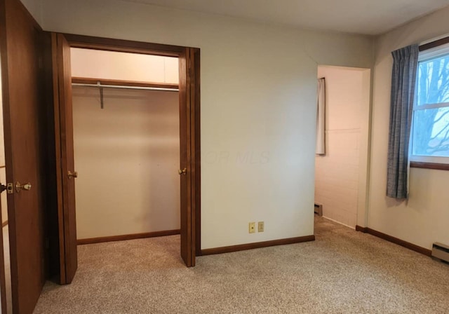 unfurnished bedroom with a closet and light carpet