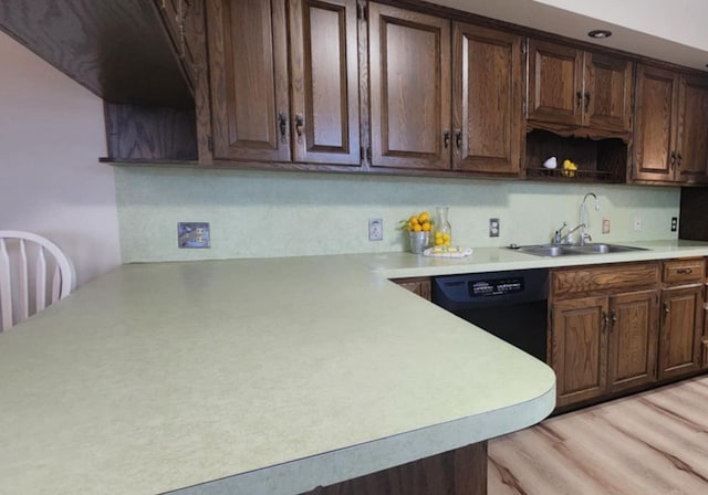 kitchen featuring dishwasher, dark brown cabinets, sink, and light wood-type flooring