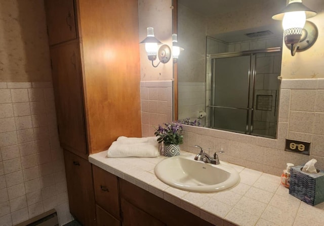 bathroom featuring tile walls, vanity, and a shower with door