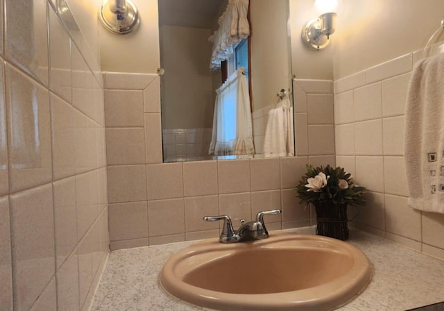 bathroom with vanity and tile walls